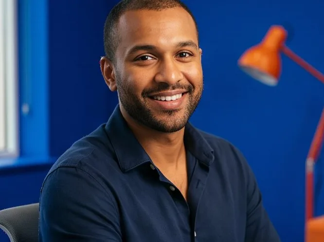 Consultant at a desk in a blue studio, orange lamp behind